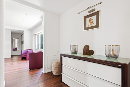 couloir avec wood finish floor, sol en finition bois, drywall, cloison sèche, et dark floor