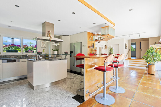 cuisine avec hotte, light floor, dark countertops, réfrigérateur, et kitchen island