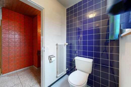 salle de bains avec tile wall, mur en carrelage, toilette, radiateur, et inside property