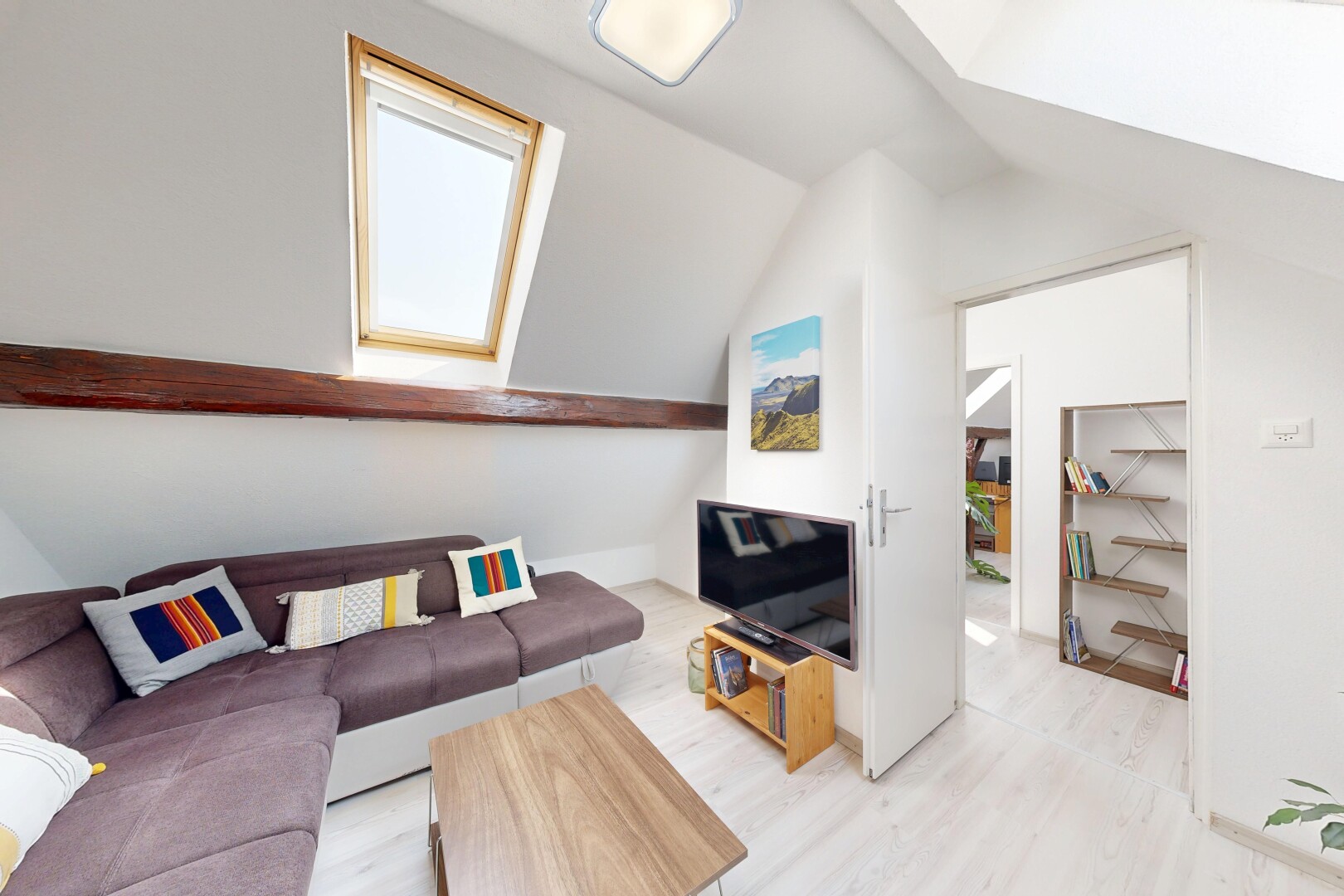 salon avec télévision, sol en finition bois, wood finish floor, plafond voûté, et vaulted ceiling