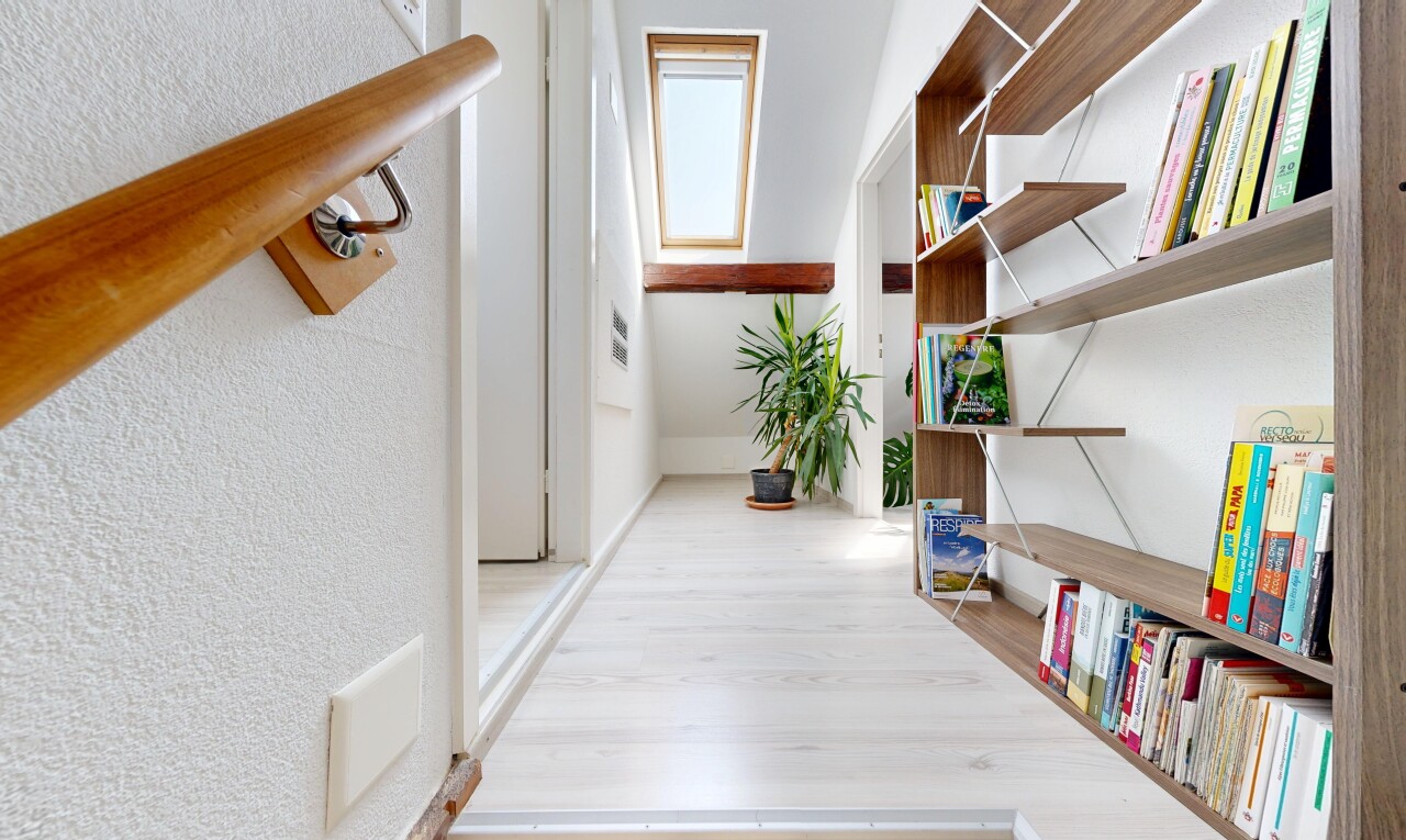 couloir avec wood finish floor, sol en finition bois, textured wall, mur texturé, et lumière naturelle