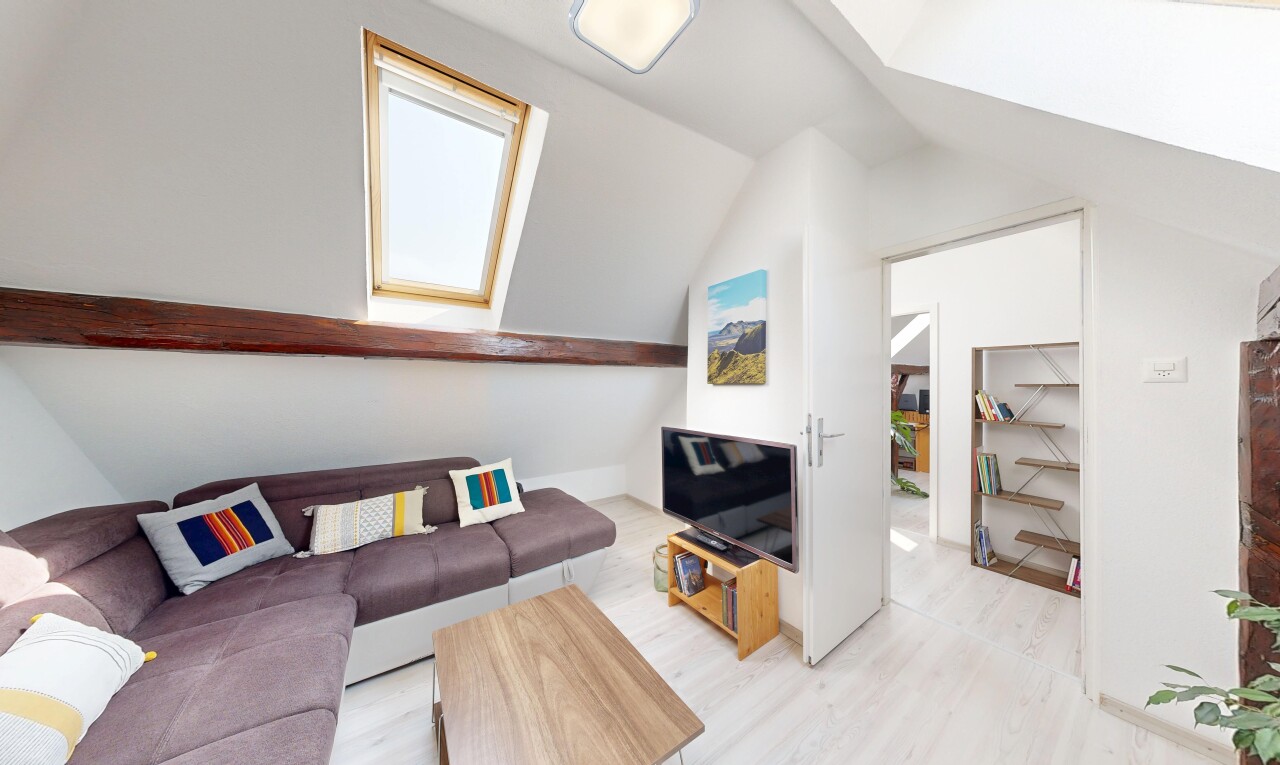 salon avec télévision, sol en finition bois, wood finish floor, plafond voûté, et vaulted ceiling