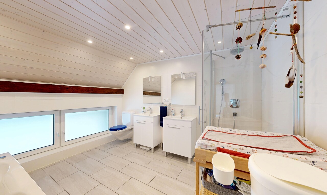 salle de bains avec miroir, toilette, deux lavabos simples, douche, et salle de bain complète