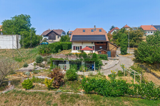 façade avec property visible, panneaux solaires, cheminée, drone view, et day time