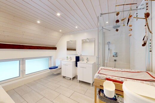 salle de bains avec miroir, toilette, deux lavabos simples, douche, et salle de bain complète