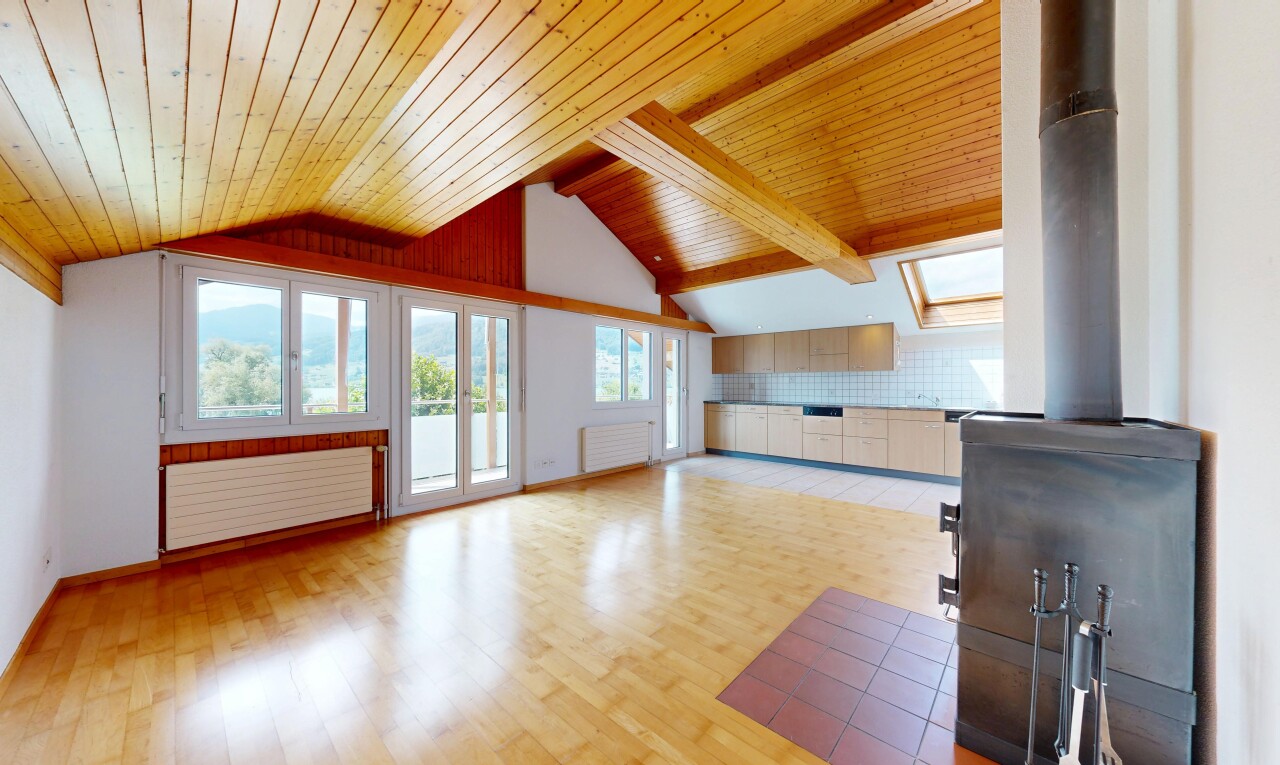 leerer raum mit holzofen, natürliches licht, vaulted ceiling, dachschräge, und wood finish floor