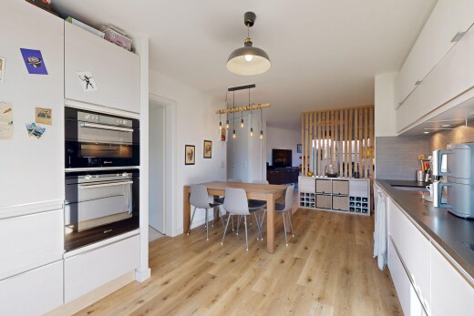 küche mit holzfußboden, arbeitsplatten, pendelleuchte, und weiße schränke