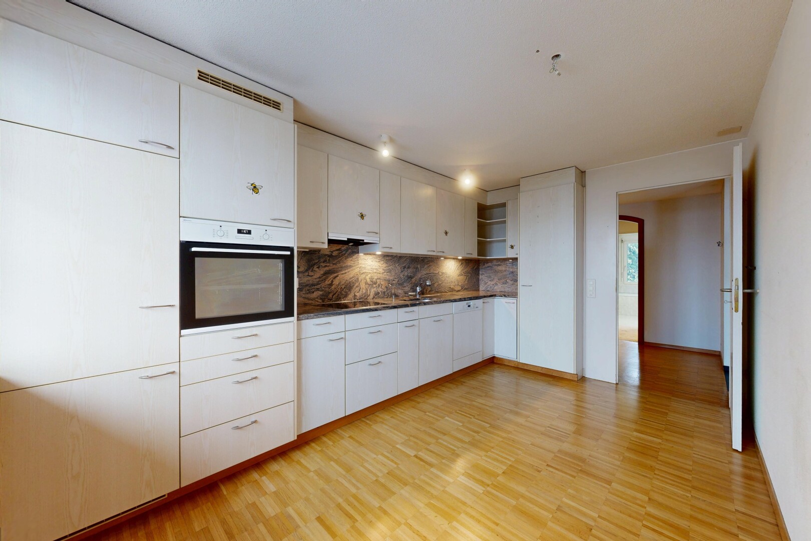 cuisine avec plans de travail, armoires blanches, four, étagères ouvertes, et inside property