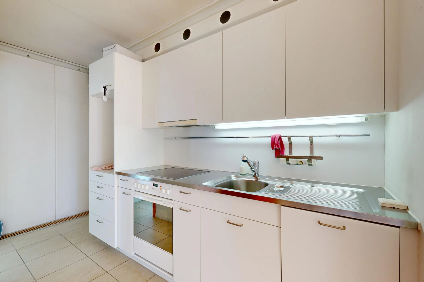 kitchen with stainless steel counters, white cabinets, and oven