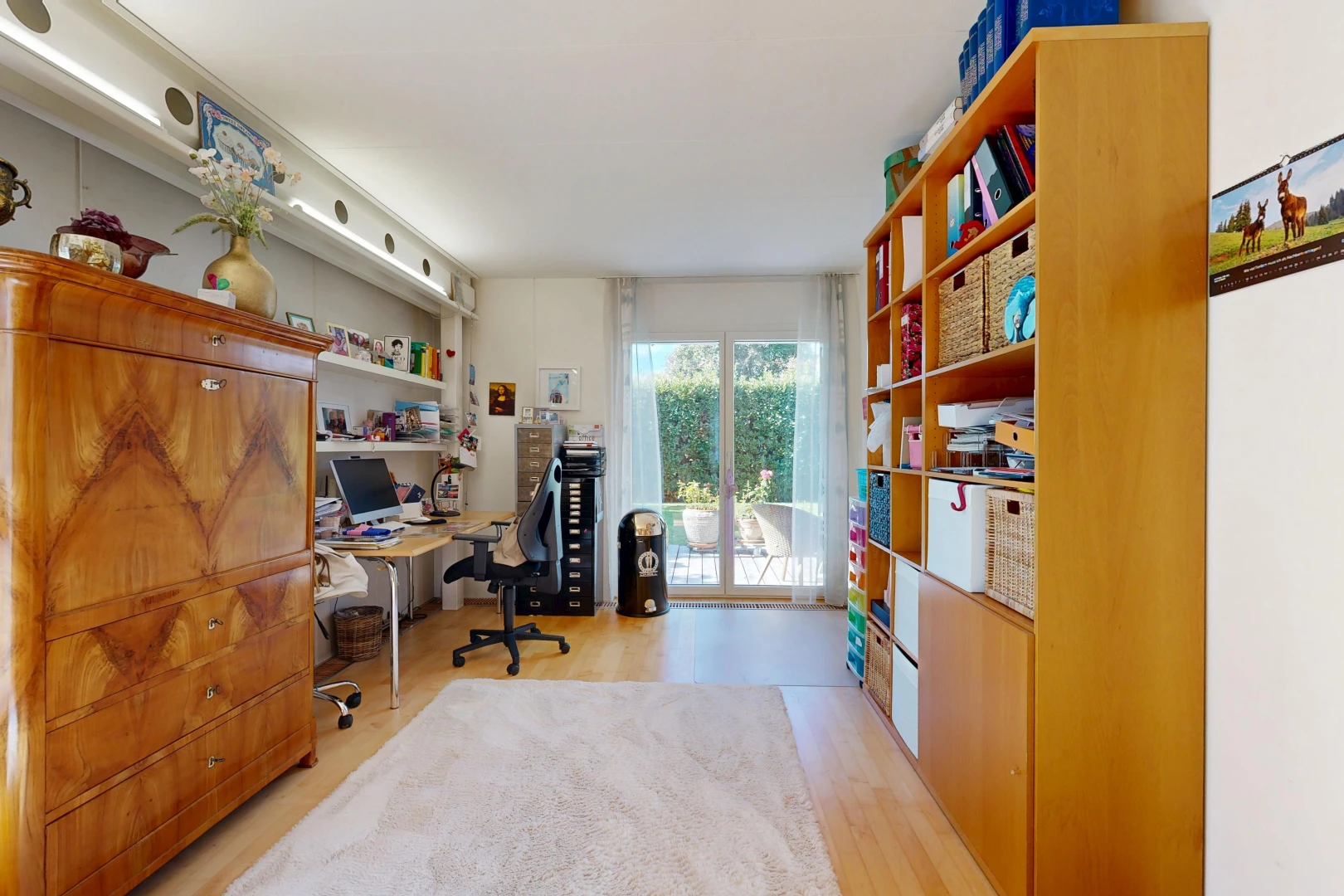 office with access to outside and light wood-style flooring