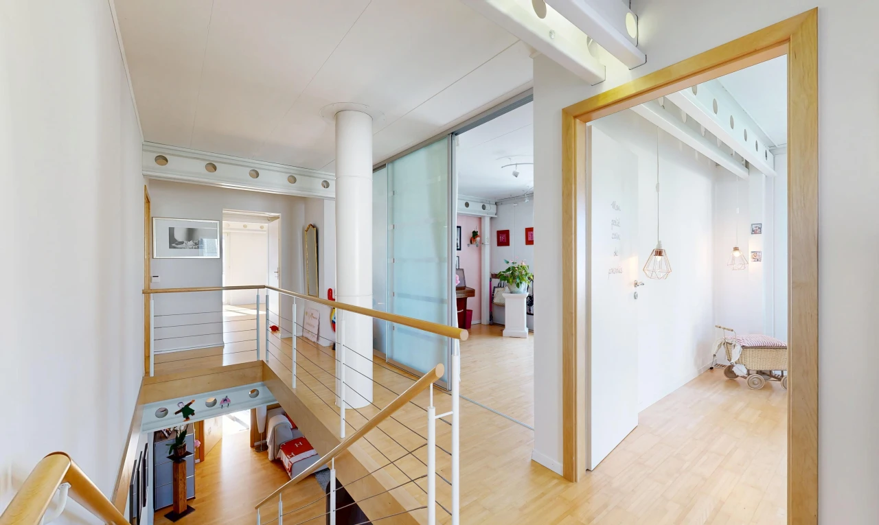corridor featuring light wood-type flooring and an upstairs landing