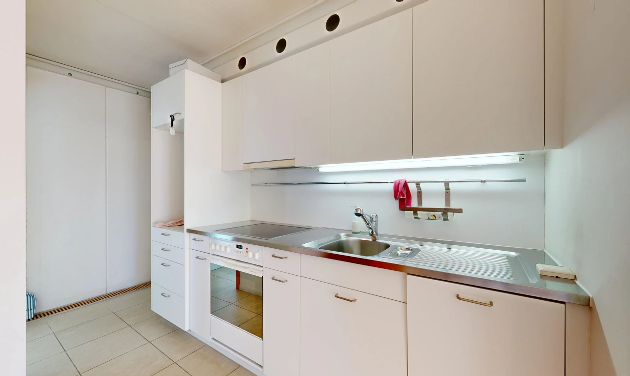 kitchen with stainless steel counters, white cabinets, and oven