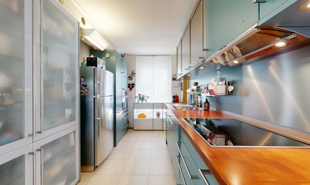 kitchen with freestanding refrigerator, black electric cooktop, and light tile patterned floors