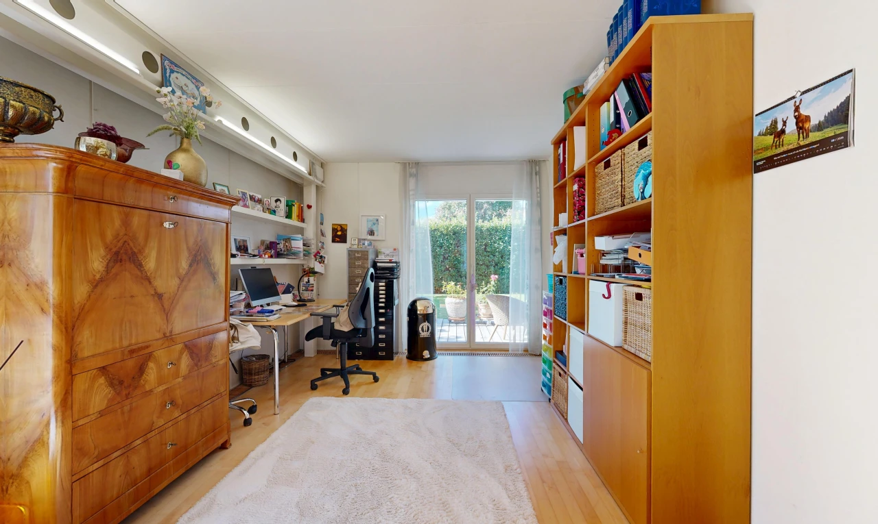 office with access to outside and light wood-style flooring
