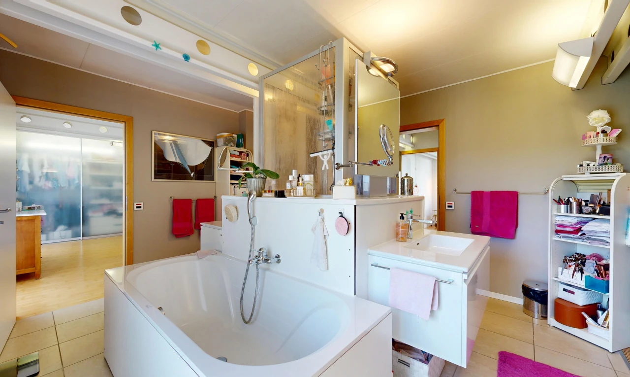 bathroom with a garden tub, vanity, and light tile patterned floors