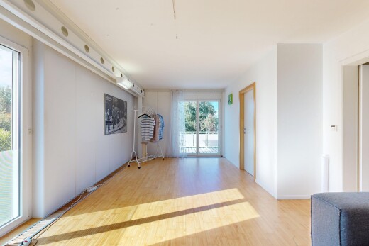 pièce vide avec accès à l'extérieur, cloison sèche, drywall, sol en finition bois, et wood finish floor