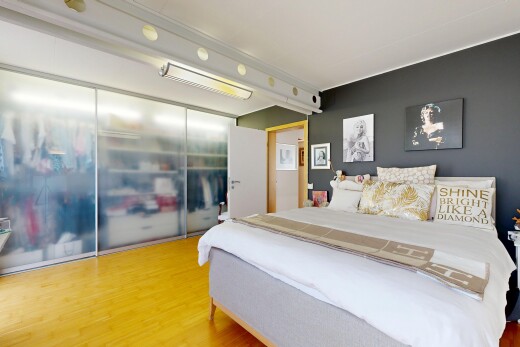 chambre avec wood finish floor, sol en finition bois, placard, inside property, et éclairage sur rail