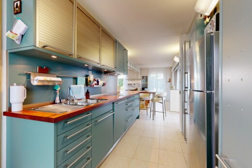 cuisine avec light floor, réfrigérateur, évier, butcher block countertops, et plans de travail en bois de boucher