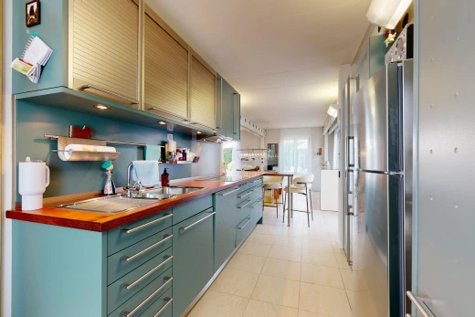 kitchen with freestanding refrigerator, wood counters, and light tile patterned floors