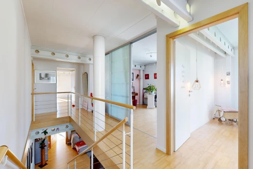 corridor featuring light wood-type flooring and an upstairs landing