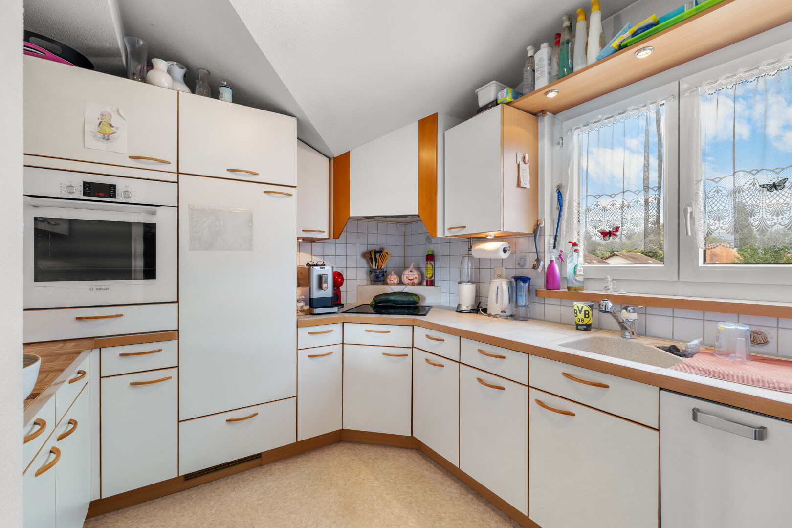 cuisine avec plans de travail, dosseret, backsplash, four, et lumière naturelle