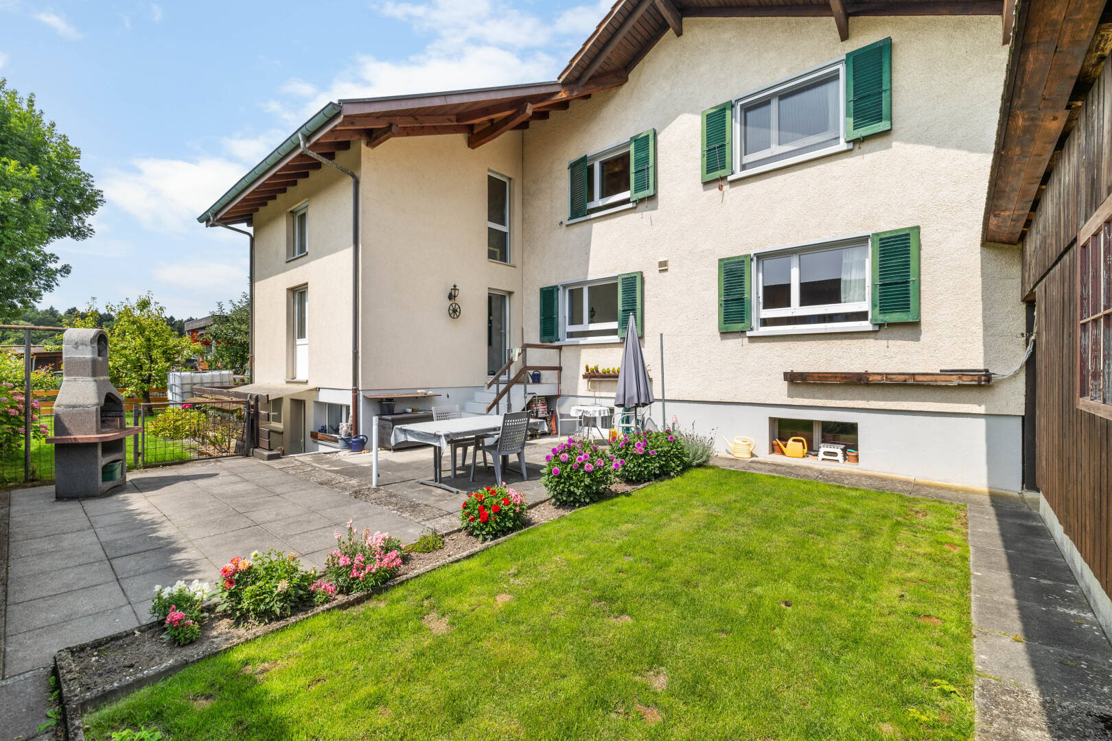 façade avec bardage en stuc, terrasse, property visible, pelouse, et day time