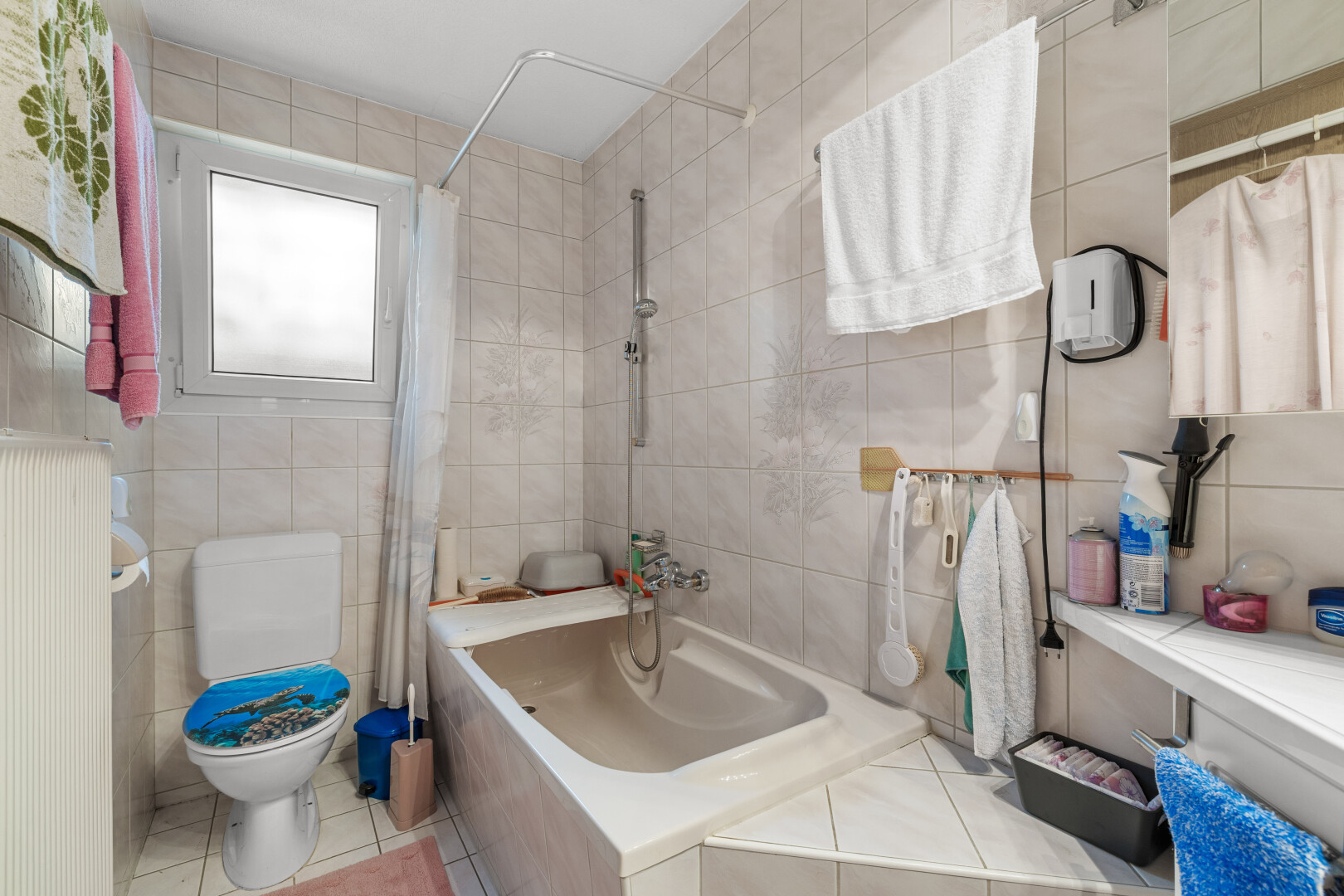salle de bains avec inside property, salle de bain complète, tile wall, mur en carrelage, et natural light