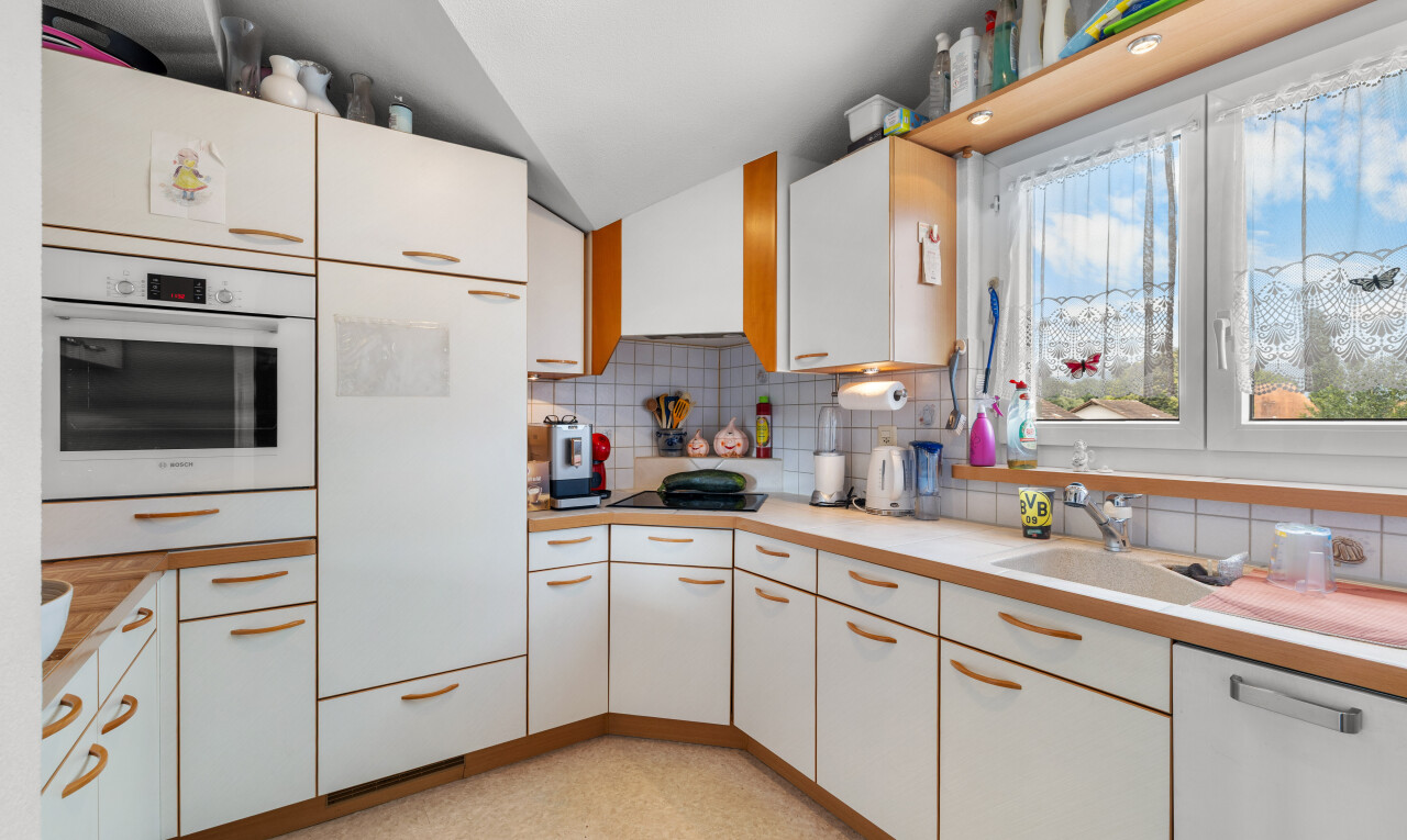 cuisine avec plans de travail, dosseret, backsplash, four, et lumière naturelle