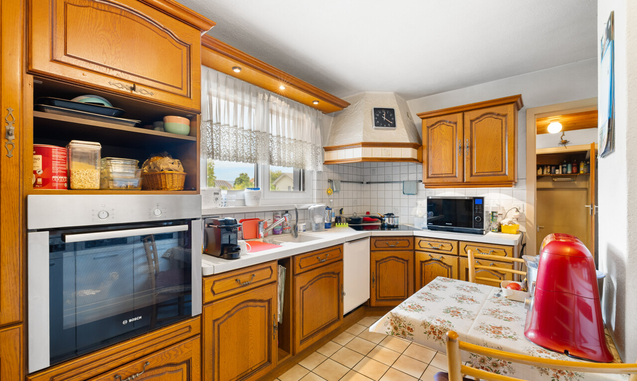 cuisine avec armoires en arc, four, plans de travail, sol en carrelage, et tile floor