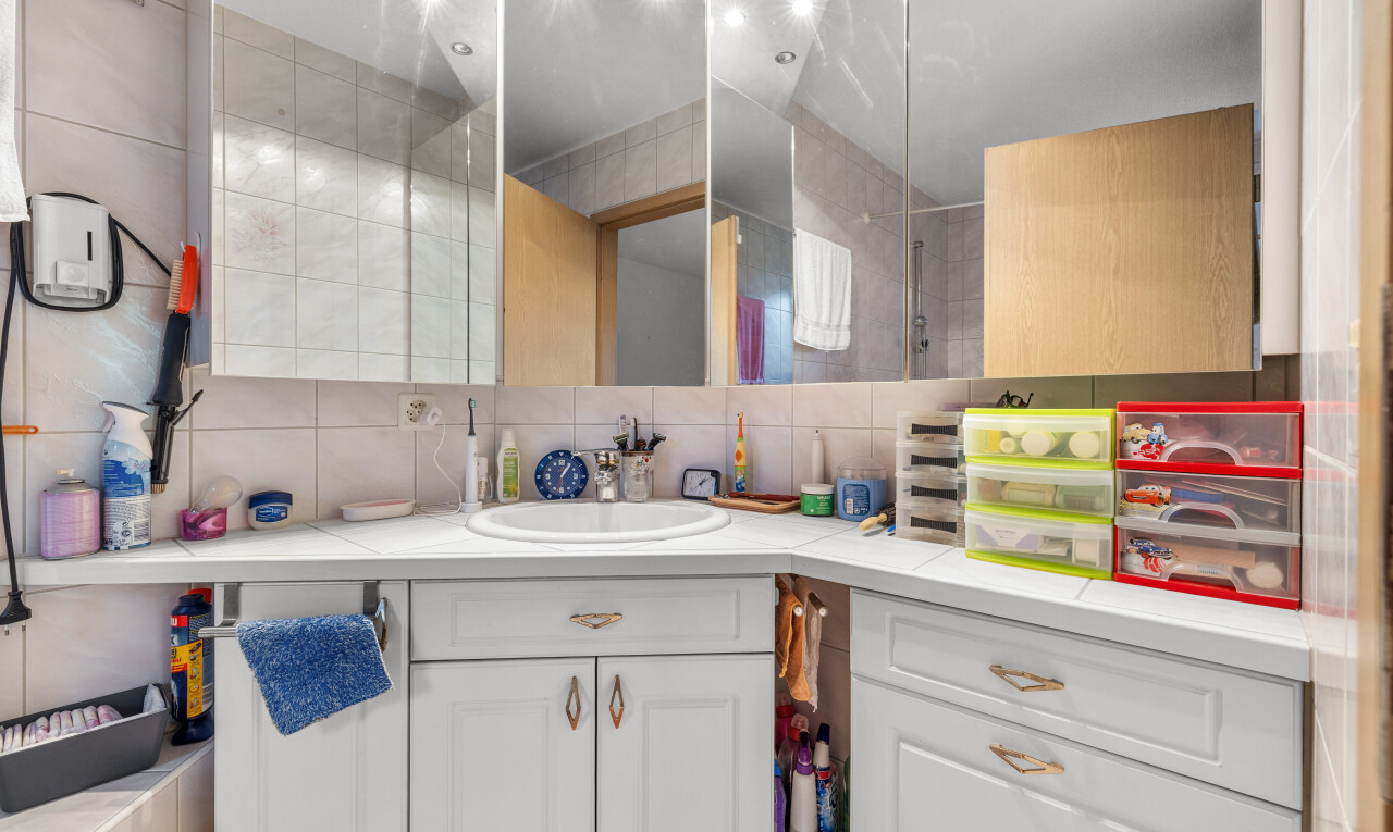 salle de bains avec lavabo (ou coiffeuse selon le contexte), miroir, dosseret, backsplash, et inside property