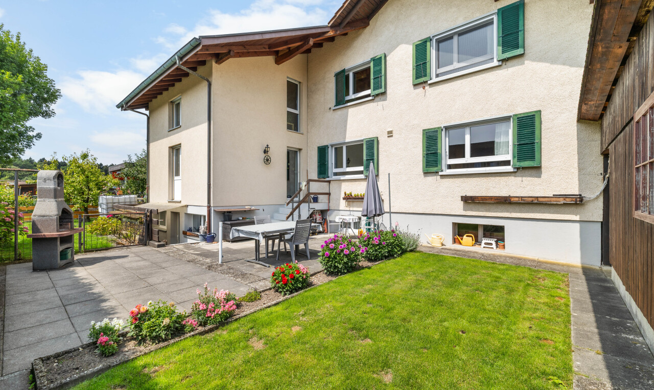 façade avec bardage en stuc, terrasse, property visible, pelouse, et day time