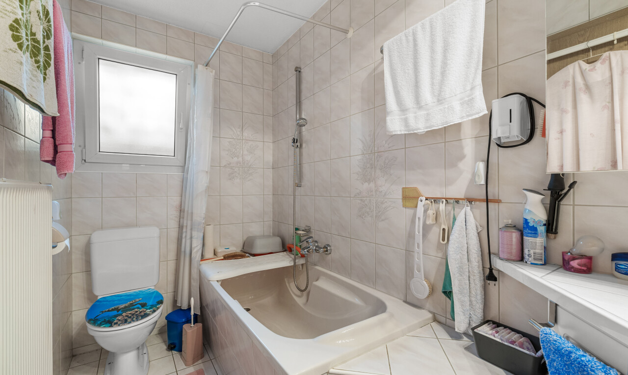 salle de bains avec inside property, salle de bain complète, tile wall, mur en carrelage, et natural light