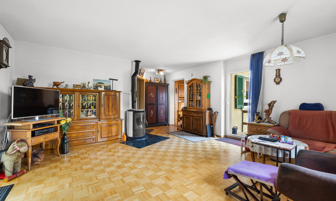 salon avec parquet floor, télévision, poêle à bois, lumière naturelle, et natural light