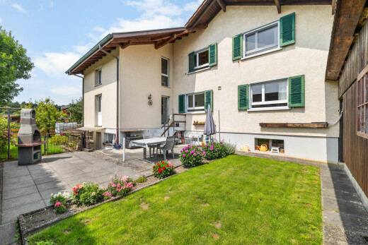 façade avec bardage en stuc, terrasse, property visible, pelouse, et day time