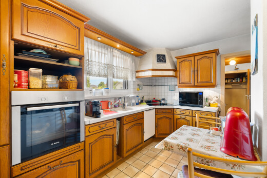cuisine avec armoires en arc, four, plans de travail, sol en carrelage, et tile floor