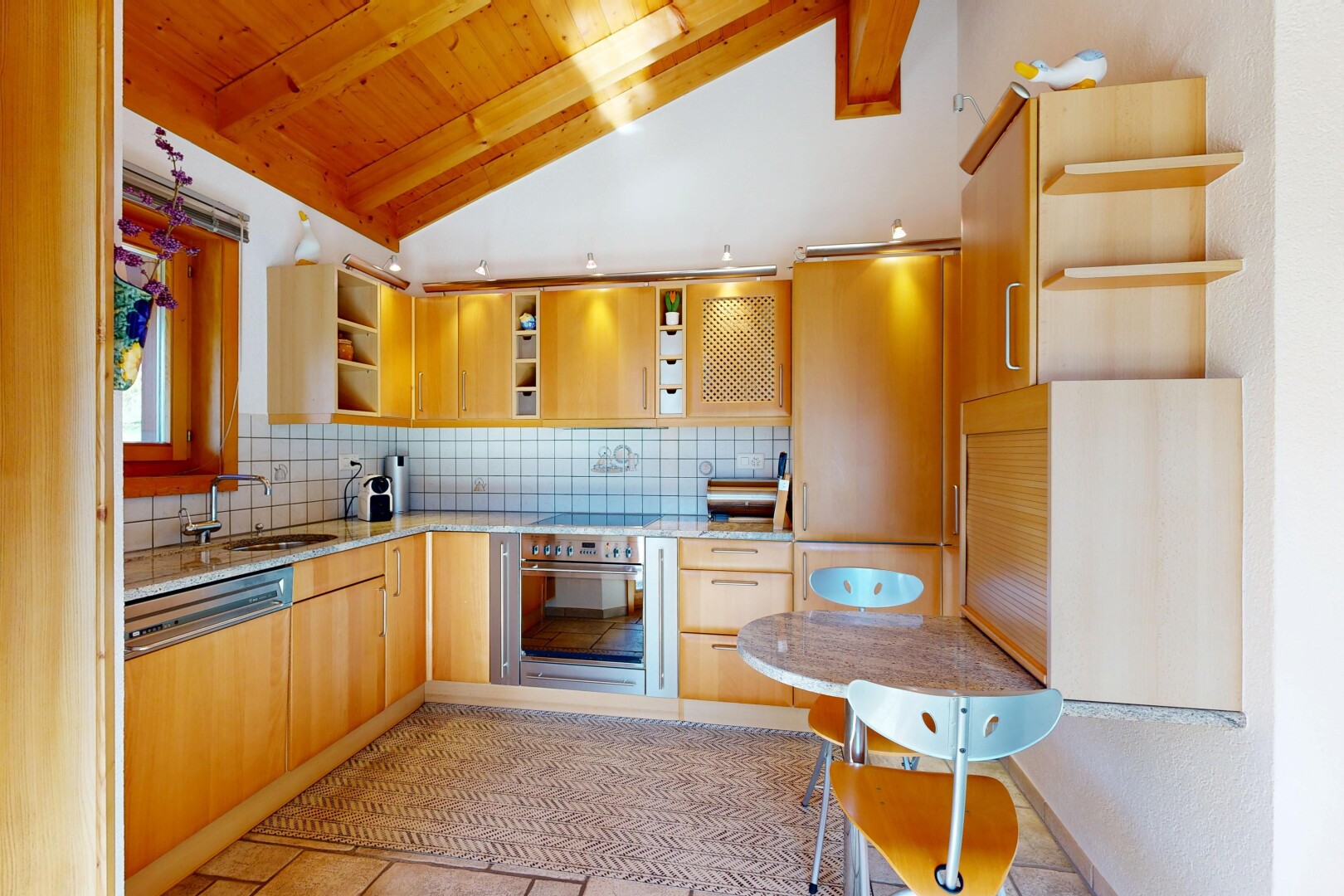 cuisine avec étagères ouvertes, open shelves, light countertops, plafond voûté, et vaulted ceiling