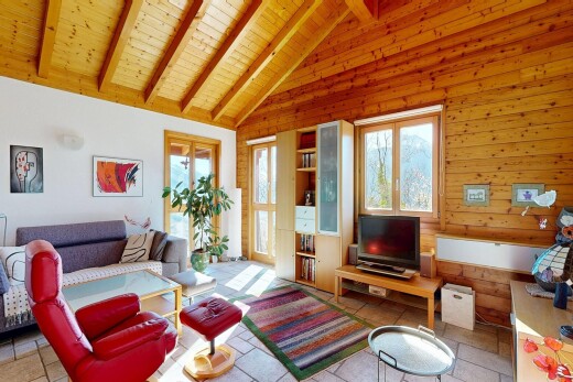 salon avec inside property, beamed ceiling, plafond à poutres, télévision, et vaulted ceiling