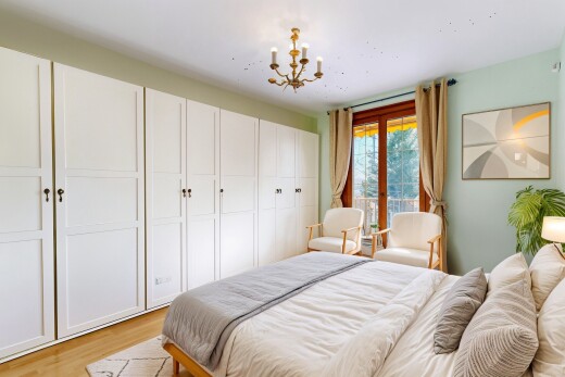 zimmer / schlafzimmer mit holzfußboden, bemerkenswerter kronleuchter, natürliches licht, und gipskartonwand