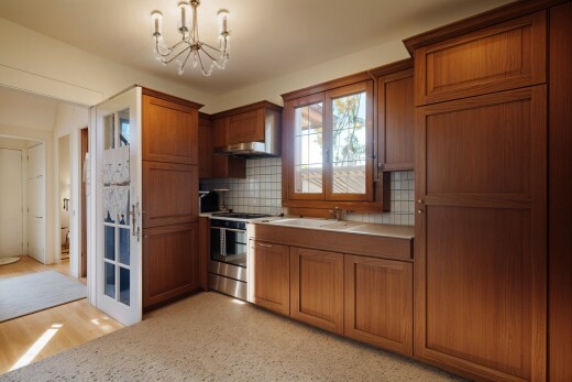 küche mit natürliches licht, bemerkenswerter kronleuchter, mittelbraune schränke, und herd