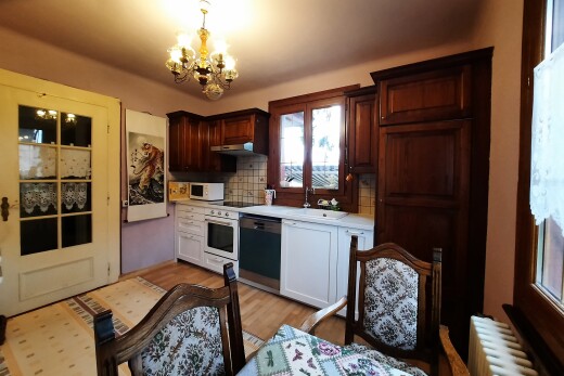 cuisine avec plans de travail, lustre remarquable, radiateur, sol en finition bois, et wood finish floor