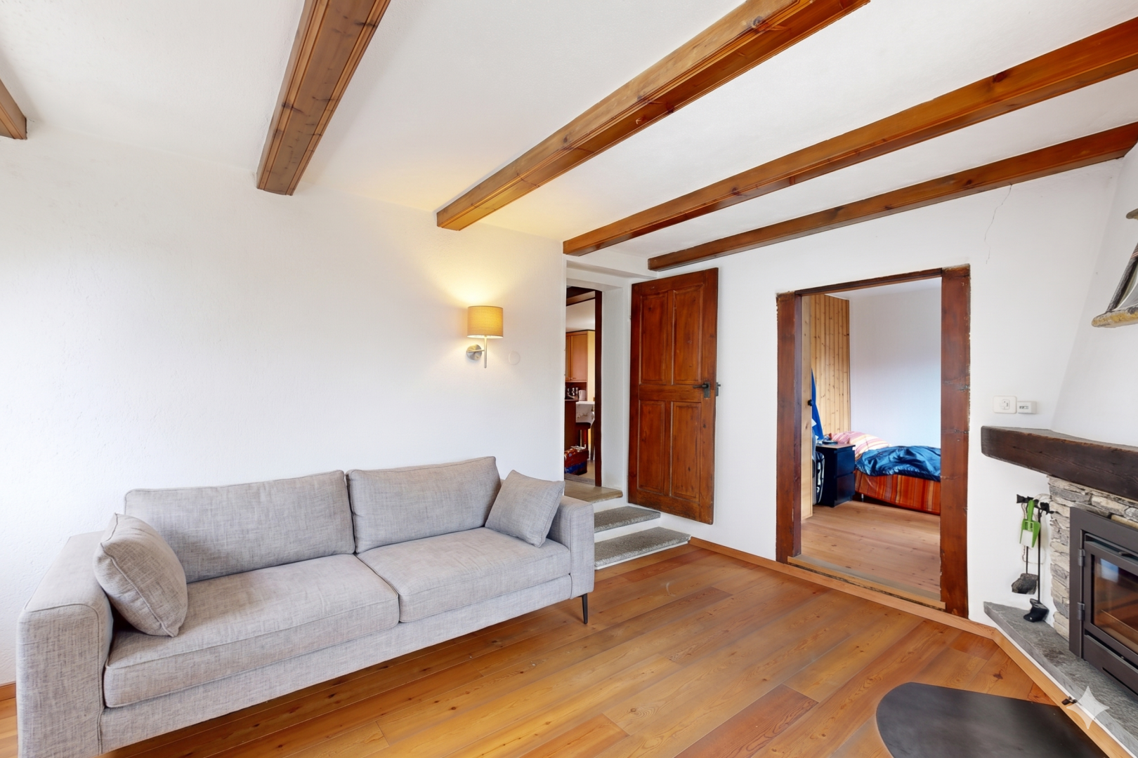 wohnzimmer mit inside property, holzfußboden, wood finish floor, kamin, und balkendecke
