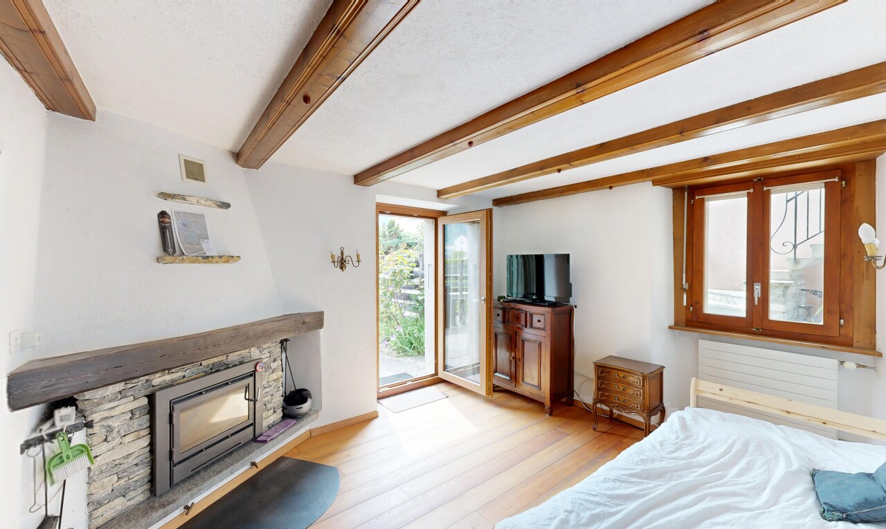 zimmer / schlafzimmer mit light floor, holzfußboden, wood finish floor, inside property, und kamin