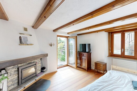 room with light wood finished floors, a fireplace, access to exterior, and beam ceiling