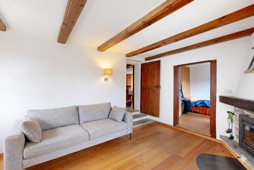 wohnzimmer mit inside property, holzfußboden, wood finish floor, kamin, und balkendecke