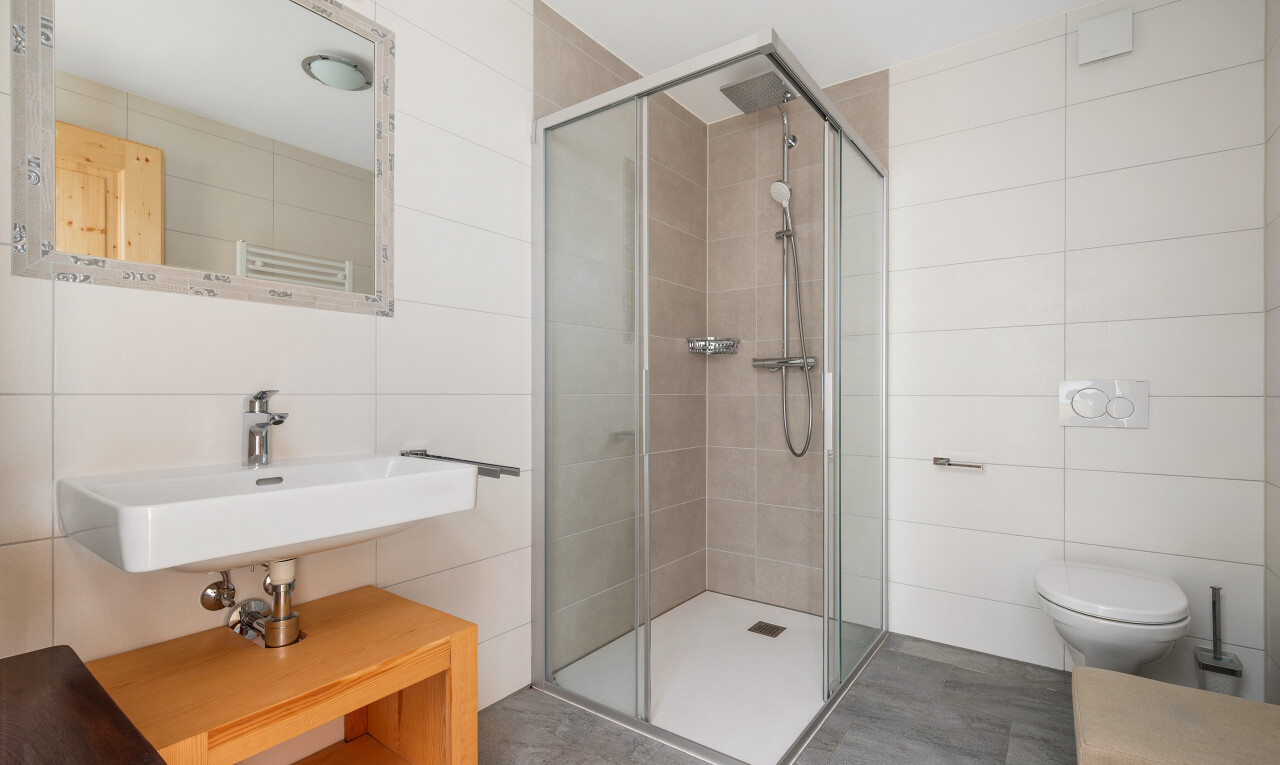 full bath with tile walls and a stall shower