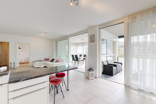 küche mit küchenbar, natürliches licht, fliesenboden, und weiße schränke