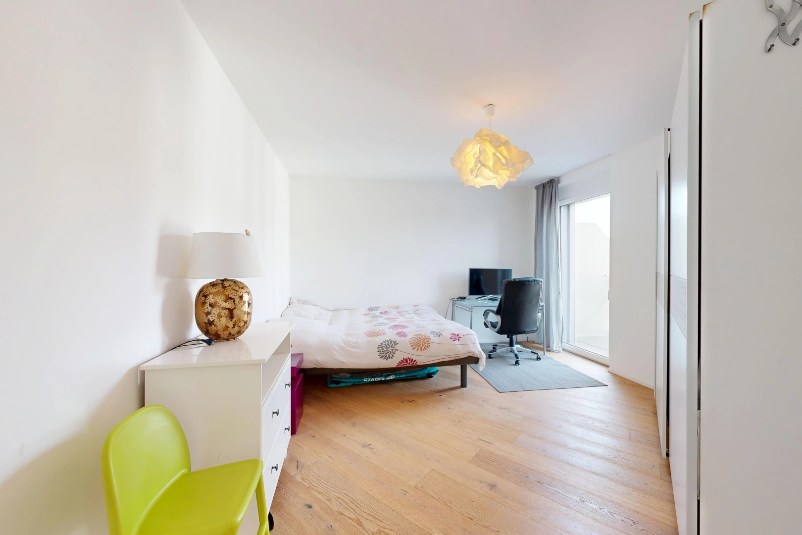 chambre avec drywall, cloison sèche, télévision, espace bureau, et wood finish floor