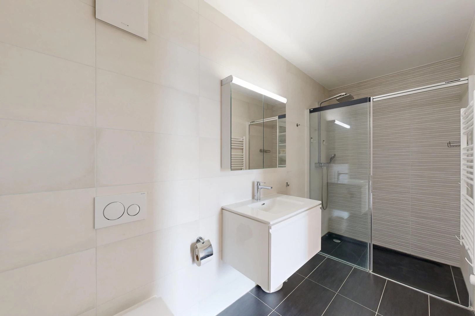 salle de bains avec chauffe-serviettes, douche, miroir, salle de bain complète, et lavabo (ou coiffeuse selon le contexte)