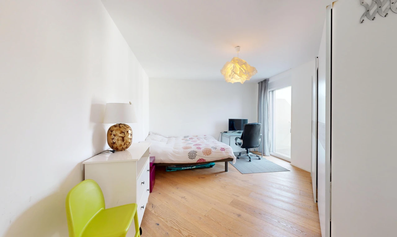 chambre avec drywall, cloison sèche, télévision, espace bureau, et wood finish floor