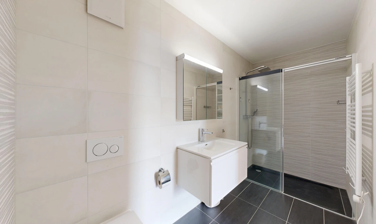 salle de bains avec chauffe-serviettes, douche, miroir, salle de bain complète, et lavabo (ou coiffeuse selon le contexte)